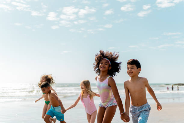 istock Friends children running through the beach 2122360975