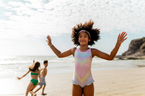 istock Child girl playing and jumping on the beach 2122362543