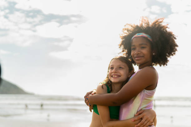istock Friends children embracing on beach 2122365176