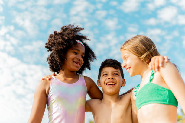 istock Friends children embracing on the beach 2122365192