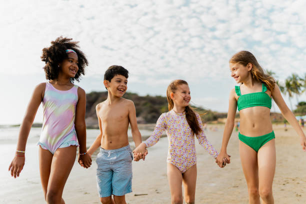 istock Friends children holding hands walking through the beach 2122367430