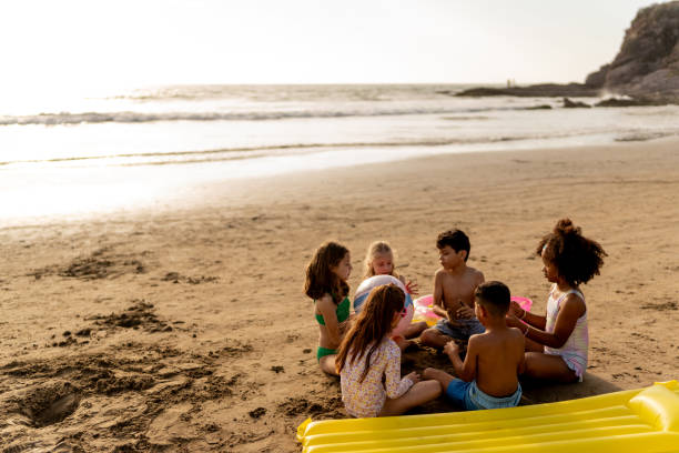 istock Friend children talking and playing on the beach 2122369533