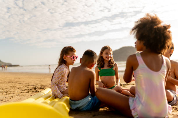 istock Friend children talking and playing on the beach 2122369551