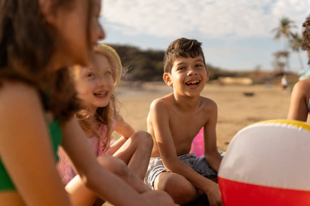 istock Friend children talking and playing on the beach 2122370622
