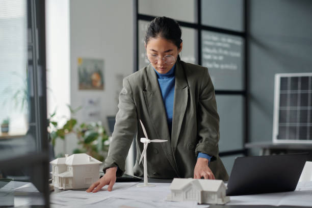 istock Woman looking at sketch on blueprint 2122378581