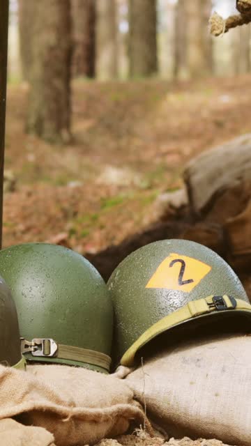 WWII American Metal Helmets Of United States Army Infantry Soldier At World War II. Helmets Near Camping Tent In Forest Camp