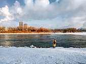 Asian Chinese female tourist photographing river bank at Jilin city, China in winter