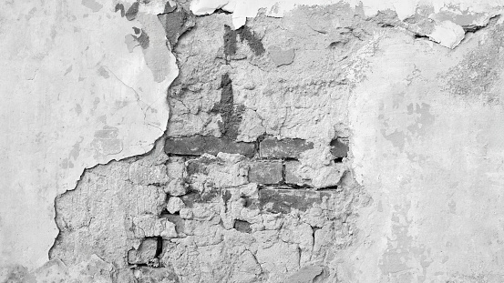 White gray grunge old dilapidated brick wall with peeling plaster as a texture background for a page, template or web banner