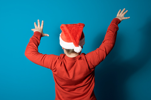 Funny Christmas concept. A boy dressed as Santa with his back to the camera in a scary pose