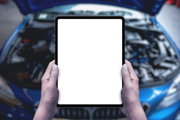istock Serviceman holds a tablet in front of a car with an open engine compartment. Isolated display for service promotion, applications, parts sales 2122479986