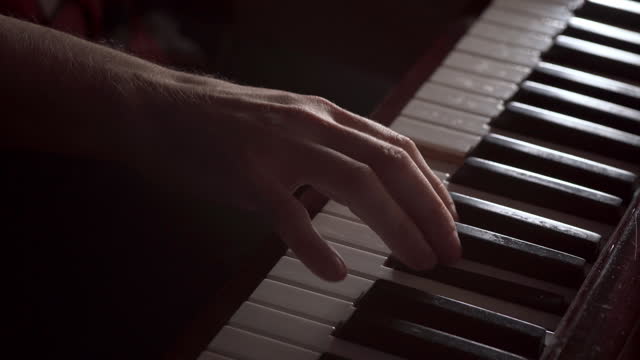 Close-up fingers of male pianist at the piano keys. Hands of musician playing at piano.
