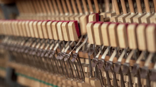 Close-up of inside the piano with string, pins and hammers