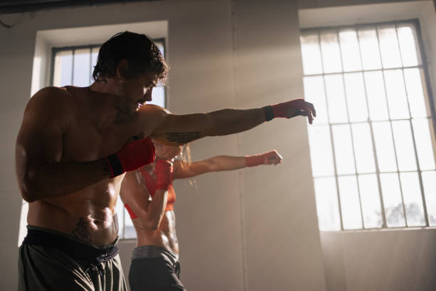 istock Two boxing partners engage in a sparring session, working on their punches and physical conditioning in a gym. 2122499344