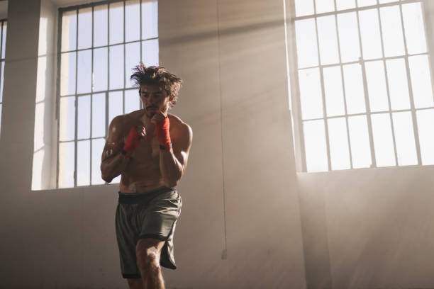 Boxer Practicing Punches in a Bright Training Gym