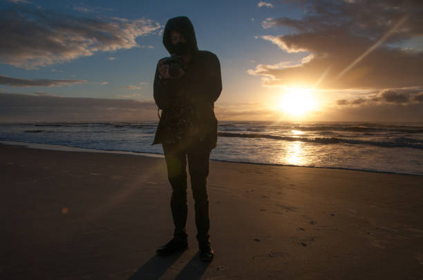 Man photographing the sea at dawn