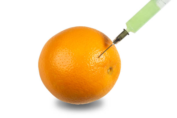 A green syringe is inserted into an orange