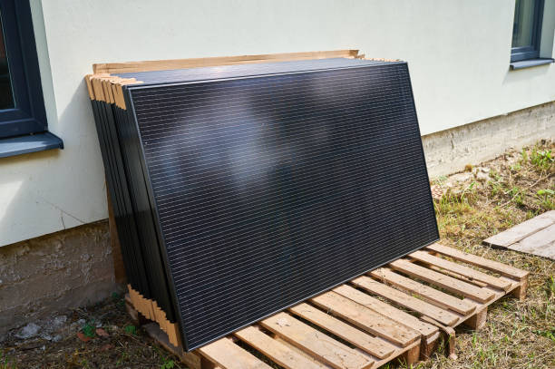 Stack of new solar panels with protective cardboard, ready for installation. Renewable energy, sustainable home improvements, and eco-friendly investments in residential property infrastructure.
