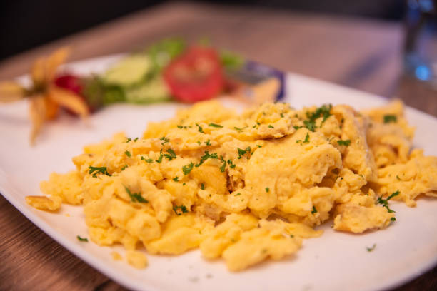 istock Scrambled eggs lie on a plate on a wooden table 2122527768
