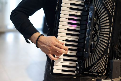 Unrecognizable Caucasian male playing an accordion.