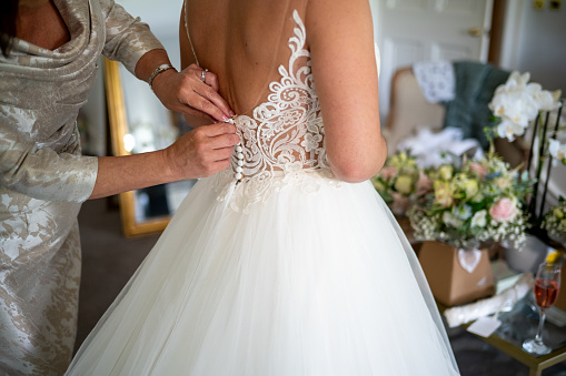 Brides Dress being Buttoned Up