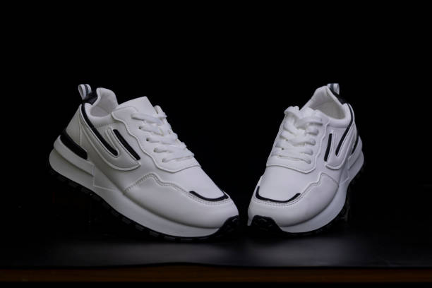 istock White sports sneakers on a black background 2122581093