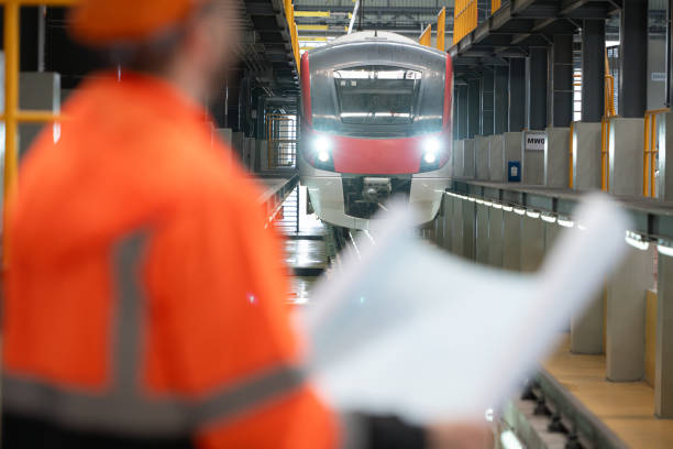 istock Portrait of a young male technician using a blueprint working and standing in a skytrain repair station. 2122619377
