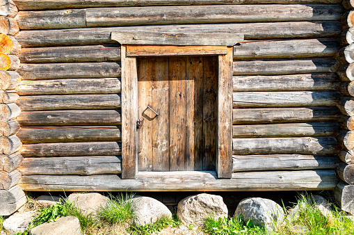 Door in old wooden log house with natural patterns. Vintage wooden house