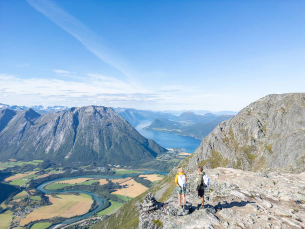 istock Two hiking adventurers overlooking a Fjord 2122657093