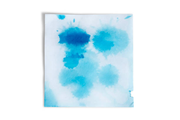 Blue blots on a white crumpled sheet of paper isolated on a white background.
