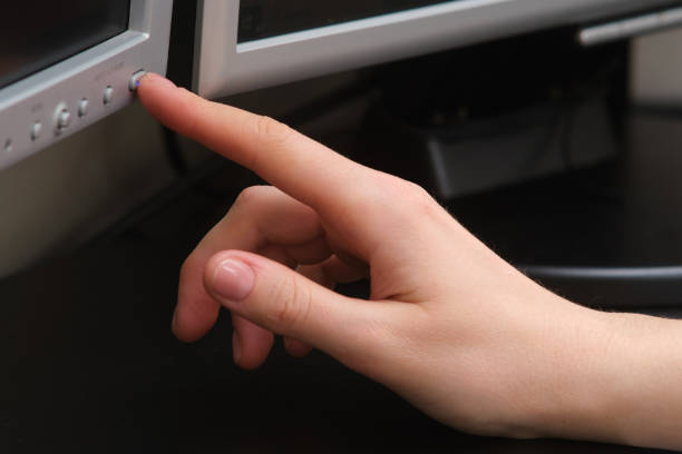 istock A woman's hand presses the power button on a computer monitor 2122670496