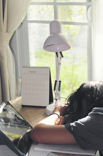 Lazy Child sleeping at desk, doing and study homework. Kid learn and work, using tablet, girl working online at home. Asian elementary Children Writing Letter on diary book. Education concept-banner.