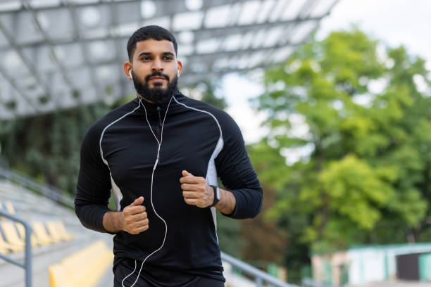 istock Active bearded man jogging outdoors with headphones 2122675260