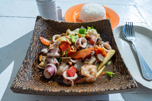 Stir fried cashew nut with seafood and vegetable in plate, close up