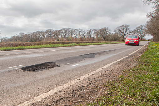 A pothole on a fast rural road in the UK.