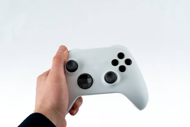 istock Hand holding white game controller in  first person view, isolated on white. 2122715489