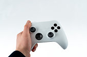 Hand holding white game controller in  first person view, isolated on white.