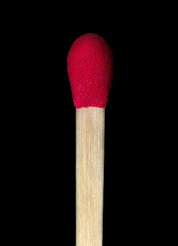 A closeup of a matchstick on a black background