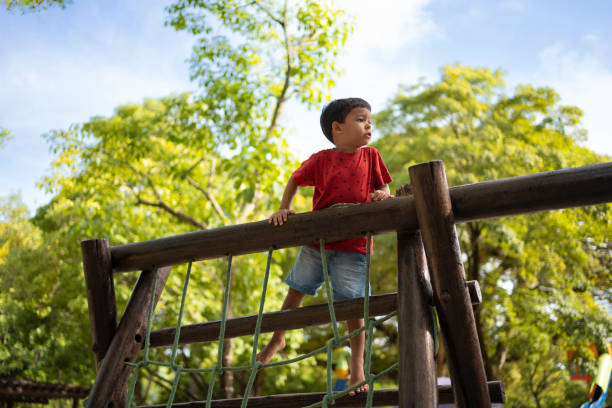A child walks along a suspension bridge over a mountain river.