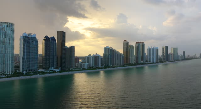 Aerial view of Sunny Isles Beach city with luxurious waterfront hotels and condos on Atlantic ocean shore. American tourism infrastructure in southern Florida