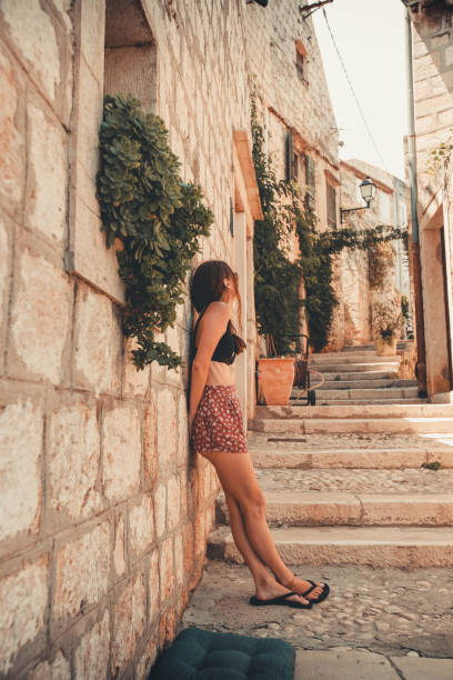 istock Young woman relaxes on stone steps in old village 2122829505