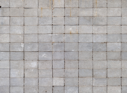 Wall made of rectangular cinder blocks with stack bond checkered pattern. Full-frame flat background and texture.