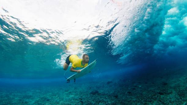 istock Surfer dives under the wave with surfing board 2122868448