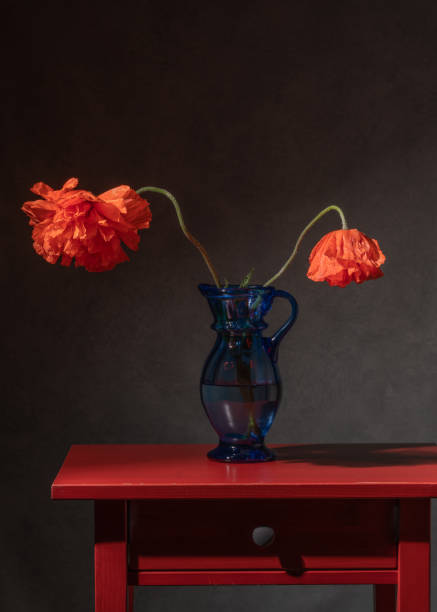 istock 2 poppies in a blue vase on a bedside table 2122920673