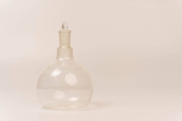 A clear glass bottle with a stopper, ideal for chemical experiments, is displayed on a clean white background. This versatile container is perfect for laboratory use.