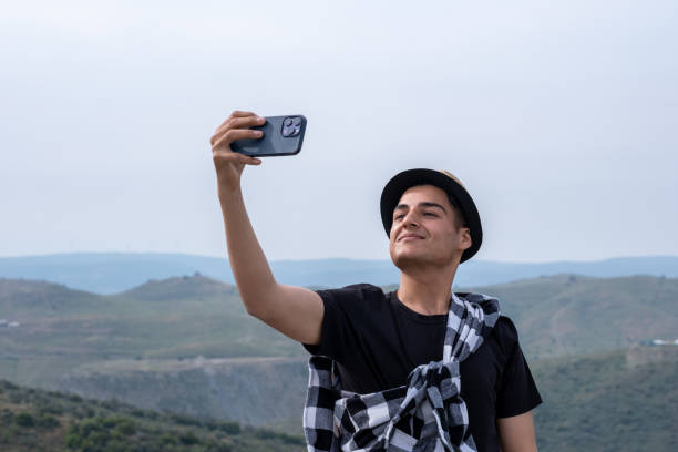 istock young man taking a sellfie while walking in nature 2122940999