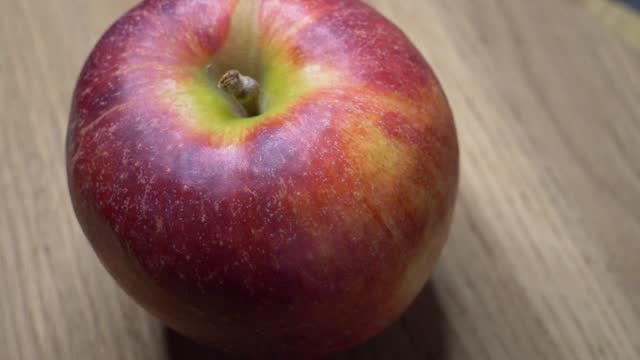 One large ripe gala apple in close-up. Video with rotating apple.