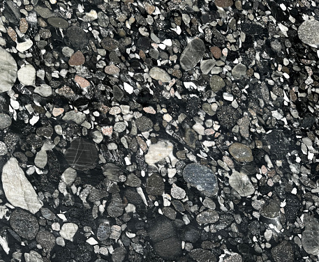 Close up photo of black galaxy or black terrazzo granite slab mainly used for wall finishes or floor finishes. Luxurious feel. seamless texture.