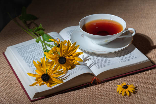 istock Open book with flowers and a cup of tea 2123017968