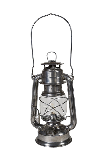 Old kerosene lamp isolated on white background. Antique metal lantern with hanging hook. GDR production