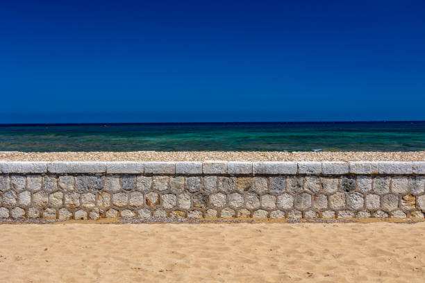 Pier and rocks. Sea piercing with a pier equipped with wooden railings. Blue sky and sea
